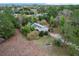 Aerial view of house with solar panels surrounded by trees and a long driveway at 21311 Sw Marine Blvd, Dunnellon, FL 34431