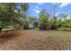 An exterior view of the house with a screened-in patio and natural landscaping in the backyard at 21311 Sw Marine Blvd, Dunnellon, FL 34431