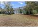 Backyard of a house with dead grass, a screened in porch, a fence, and lush trees at 21311 Sw Marine Blvd, Dunnellon, FL 34431