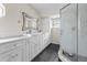 Bathroom with a double vanity, stone tile floor, walk-in shower, and large mirror at 21311 Sw Marine Blvd, Dunnellon, FL 34431