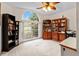 Bright bedroom with large arched window, ceiling fan, and multiple wood bookshelves at 21311 Sw Marine Blvd, Dunnellon, FL 34431