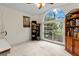 Bright bedroom features a large arched window, filled bookshelves, and neutral carpet at 21311 Sw Marine Blvd, Dunnellon, FL 34431