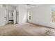 A modest bedroom shows an open door revealing a bathroom, and 2 windows for natural light at 21311 Sw Marine Blvd, Dunnellon, FL 34431