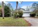 A single-Gathering home shows its front exterior with a two-car garage, mature trees and front yard at 21311 Sw Marine Blvd, Dunnellon, FL 34431