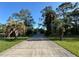 View of home down long driveway lined with mature landscaping and beautiful trees at 21311 Sw Marine Blvd, Dunnellon, FL 34431