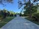 View of home down long driveway with a mature tree canopy and lush landscaping at 21311 Sw Marine Blvd, Dunnellon, FL 34431