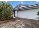 Attached two-car garage with a white door; a mature palm and established shrubbery line the front at 21311 Sw Marine Blvd, Dunnellon, FL 34431