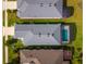 Aerial view of houses with green lawns, driveways, gray roofs, and one house with a screened in pool at 2174 Wallingford Loop, Mount Dora, FL 32757