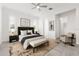 Stylish main bedroom with a plush bed, bench seating, and contemporary decor at 2174 Wallingford Loop, Mount Dora, FL 32757
