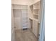 Walk-in closet featuring custom built-in shelving and ample storage space, adding convenience and organization at 2174 Wallingford Loop, Mount Dora, FL 32757