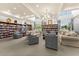 Large library boasts abundant seating, natural light from multiple windows, and walls filled with books and decor at 2174 Wallingford Loop, Mount Dora, FL 32757