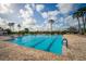 A beautiful outdoor pool with palm trees, blue skies, and comfortable lounge chairs offers a relaxing escape at 2174 Wallingford Loop, Mount Dora, FL 32757