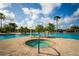 Community swimming pool with a hot tub, palm trees, lounge chairs, and clear blue skies at 2174 Wallingford Loop, Mount Dora, FL 32757