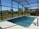 Inviting swimming pool within a screened enclosure, overlooking a lush backyard and landscaping at 2174 Wallingford Loop, Mount Dora, FL 32757