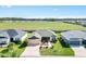 Aerial view of a residential property with a landscaped yard, neighboring homes, and an expansive green space nearby at 2188 Gordon Path, The Villages, FL 32163