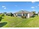 The expansive backyard features lush green grass and landscaping with a screened in patio at 2188 Gordon Path, The Villages, FL 32163