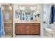 Bathroom features a double vanity with a framed mirror, a shower with glass door, and a separated toilet at 2188 Gordon Path, The Villages, FL 32163