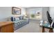 Bright bedroom with a daybed, neutral walls, and large windows dressed with shutters at 2188 Gordon Path, The Villages, FL 32163