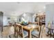 Open-concept dining area showcasing wood flooring, modern lighting, and a seamless flow into the kitchen and living spaces at 2188 Gordon Path, The Villages, FL 32163