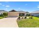 Charming single-story home featuring a well-manicured lawn, neutral-toned exterior, and attached two-car garage at 2188 Gordon Path, The Villages, FL 32163