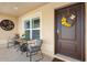Inviting front porch with cozy seating and decorative sunflower wreath on a brown door at 2188 Gordon Path, The Villages, FL 32163
