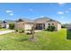 Inviting single-story home featuring a screened patio, well-manicured lawn, and beautiful landscaping at 2188 Gordon Path, The Villages, FL 32163