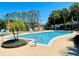 Sparkling community pool surrounded by lounge chairs and mature trees, perfect for relaxation and recreation at 2207 Black Hawk St, Clermont, FL 34714