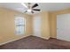 Neutral bedroom featuring plush brown carpet, a ceiling fan, and a sunlit window at 2376 Bexley Dr, Tavares, FL 32778