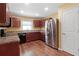 Well-lit kitchen featuring stainless steel appliances and wood cabinets at 2376 Bexley Dr, Tavares, FL 32778