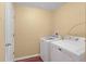 Bright laundry room with modern, white washer and dryer appliances and convenient shelving at 2376 Bexley Dr, Tavares, FL 32778