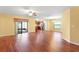 Open-concept living room with hardwood floors, flowing into the kitchen with stainless steel appliances at 2376 Bexley Dr, Tavares, FL 32778
