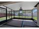 Enclosed porch with dark framing, a patterned floor, and views of the fenced backyard at 2376 Bexley Dr, Tavares, FL 32778