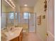 Well-lit bathroom features tile flooring, a glass-enclosed shower, vanity, and modern fixtures at 24104 Robinwood St, Leesburg, FL 34748