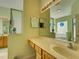 Bathroom vanity with double mirrors and light wood cabinetry, offering ample counter space and storage at 24104 Robinwood St, Leesburg, FL 34748