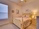 Bedroom with a light yellow bed frame, neutral bedding, a ceiling fan, and natural light from the window at 24104 Robinwood St, Leesburg, FL 34748