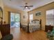 Cozy bedroom features a decorative metal bed frame and sliding glass door to the patio at 24104 Robinwood St, Leesburg, FL 34748