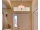 Bright entryway featuring a decorative light fixture, sidelight window, and a white door at 24104 Robinwood St, Leesburg, FL 34748