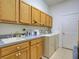 Functional laundry room featuring a sink, ample cabinetry, and modern washer and dryer units at 24104 Robinwood St, Leesburg, FL 34748