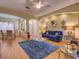 Bright living room features wood floors, a ceiling fan, and an open floor plan to the dining area at 24104 Robinwood St, Leesburg, FL 34748