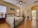 Comfortable main bedroom with a queen-size bed, wood floors, and access to the main bathroom at 24104 Robinwood St, Leesburg, FL 34748