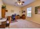 Home office space with wooden furniture, a large window, and a ceiling fan to keep the area well-ventilated at 24104 Robinwood St, Leesburg, FL 34748