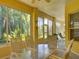 Bright sunroom featuring a glass table set, large windows with outdoor views, and comfortable seating at 24104 Robinwood St, Leesburg, FL 34748