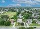 Aerial view of a home with a well-maintained lawn, mature trees, and a sparkling lake nearby at 257 Winding Cove Ave, Apopka, FL 32703