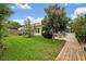 Well-maintained backyard featuring a lush lawn, mature trees, and a screened lanai, perfect for outdoor relaxation and entertaining at 257 Winding Cove Ave, Apopka, FL 32703