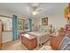 Bright bedroom with a ceiling fan, bedside tables, window view, and colorful patterned bedspread at 257 Winding Cove Ave, Apopka, FL 32703