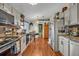 Open kitchen area with stainless steel appliances, wood-look flooring, and breakfast table at 257 Winding Cove Ave, Apopka, FL 32703