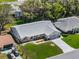 An aerial view of the well-manicured property with lush green grass and an attached two-car garage at 26800 Racquet Cir, Leesburg, FL 34748