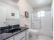 Modern bathroom featuring a shower-tub combo and a dark granite vanity at 26800 Racquet Cir, Leesburg, FL 34748