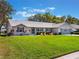 Well-maintained home featuring a lush green lawn and charming landscaping for beautiful curb appeal at 26800 Racquet Cir, Leesburg, FL 34748