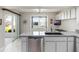 The bright kitchen has a stainless steel dishwasher and an exterior view window at 26800 Racquet Cir, Leesburg, FL 34748